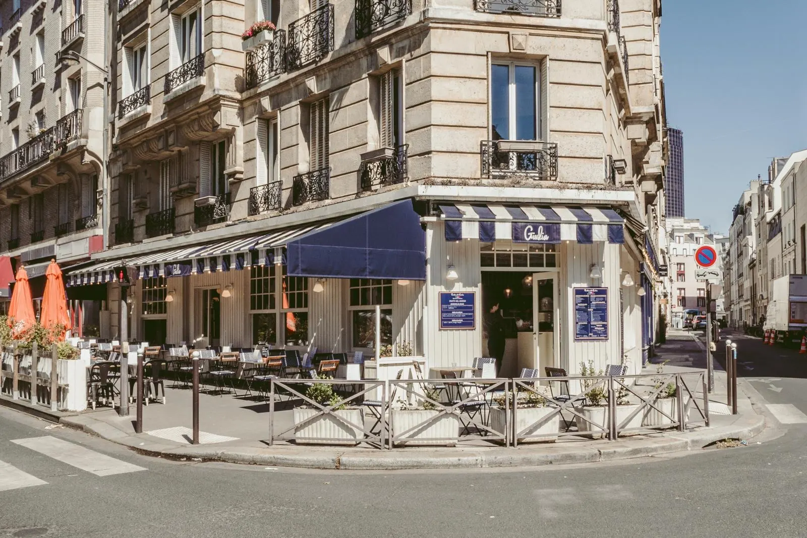 La devanture de Giulia à l'angle de la rue Édouard Jacques, store bleu et terrasse au soleil